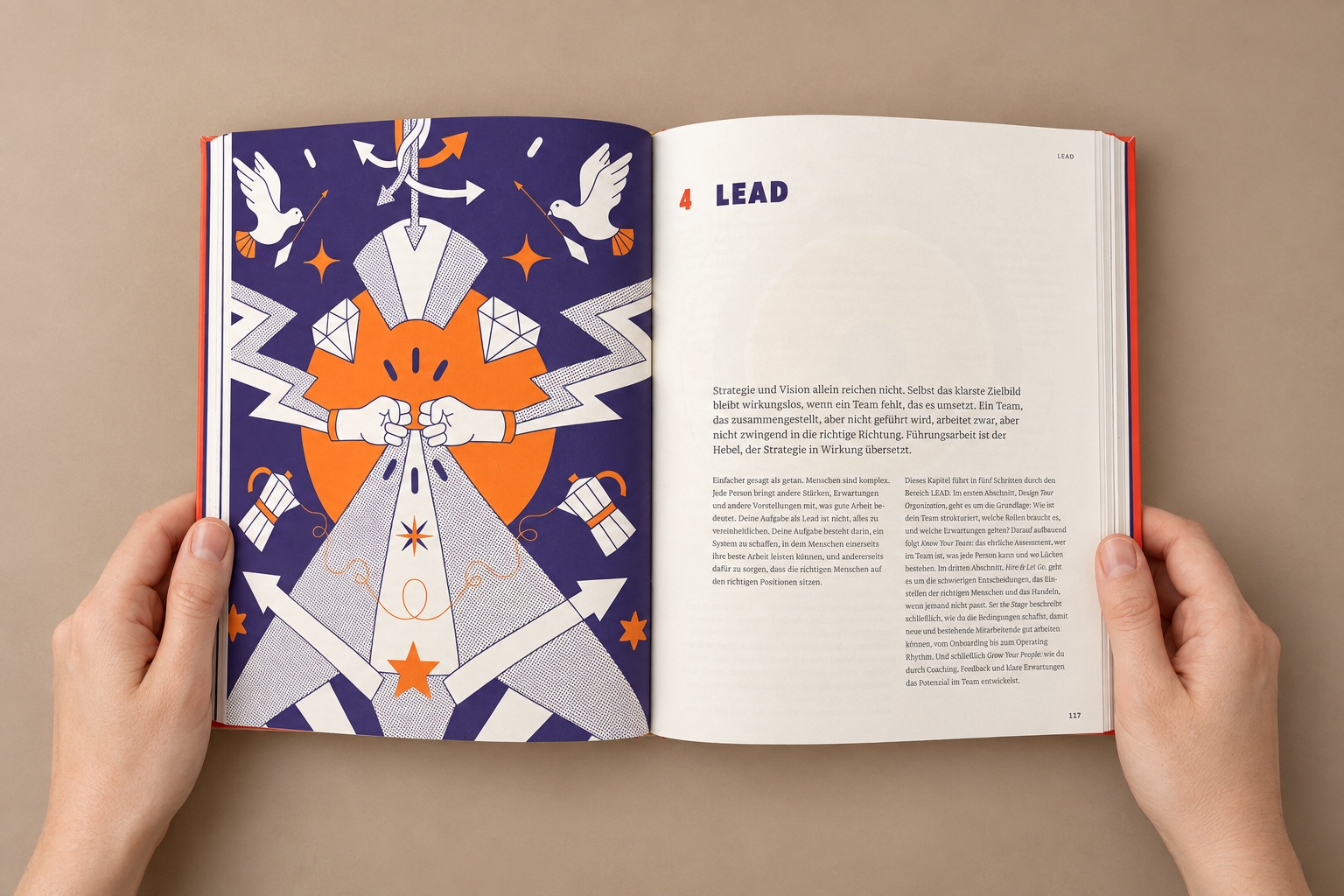 Hände halten das aufgeschlagene Drive Leadership Playbook auf einem warmen sandfarbenen Untergrund. Zu sehen ist das Kapitel Lead.
